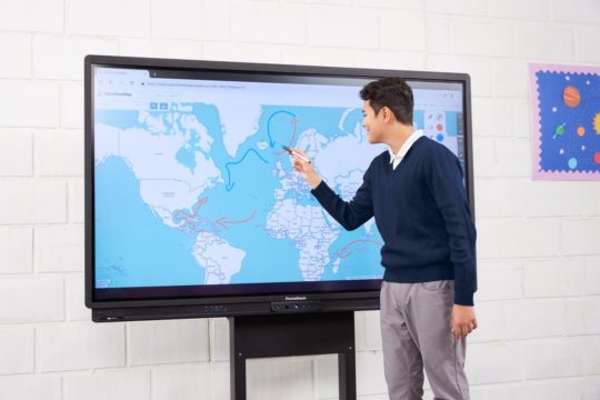 Student annotating on a world map on the Promethean ActivPanel