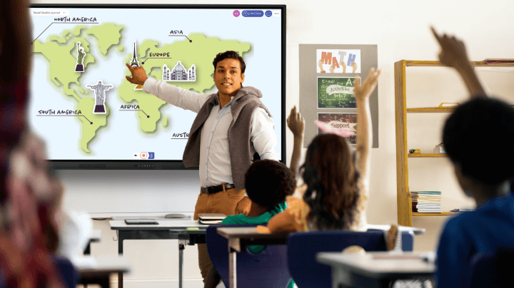 A teacher in front of the Promethean ActiVPanel instructs a group of young students.