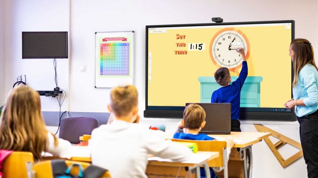 A student uses an ActivPanel 10 while a teacher walks through the lesson.